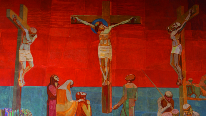 Levende muralmaleri, der skildrer korsfæstelsen af Jesus Kristus med de to røvere, omgivet af sørgende.
