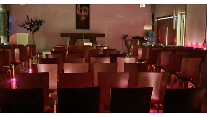 Ein leerer Raum mit vielen Stühlen und Tischen, beleuchtet in Rot und Weiß.