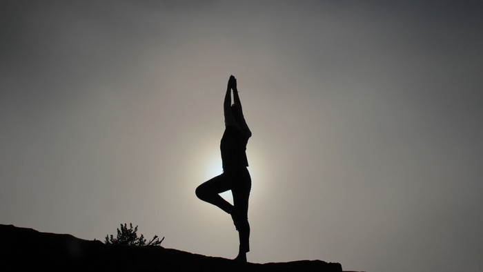 Silhouette einer Person in Yoga-Pose bei Sonnenuntergang