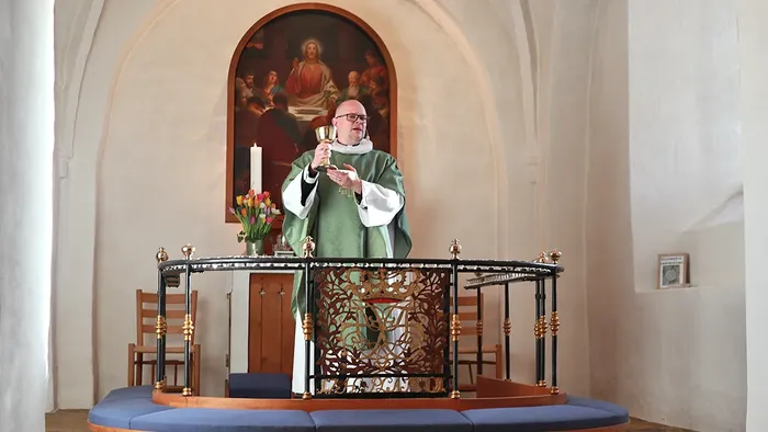 Sognepræst Troels Toft ved alter med vinbægeret