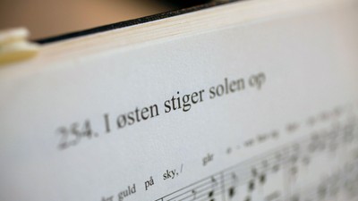 En del af en notebog med noter og tekst på dansk.