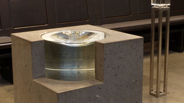 Ein modernes Waschbecken aus Beton in einem Raum mit Kerzenleuchter