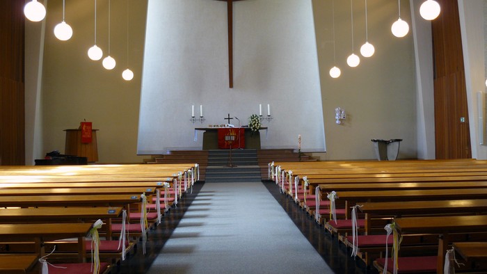 Leere Kirche mit Holzbänken und Kreuz