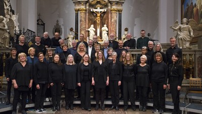 Et korhold poser formelt inde i en prægtig kirke med udsmykkede dekorationer og statuer.