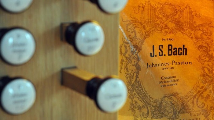 Nahaufnahme einer Orgelkonsole mit Notenblatt von J.S. Bachs „Johannes-Passion“, das deutlich sichtbar ist.