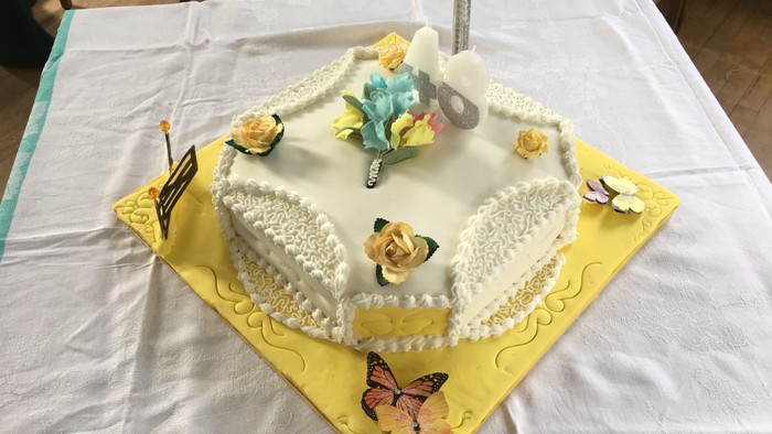 A heart-shaped cake with butterflies and flowers on top.