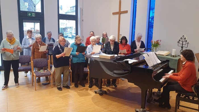 Gruppe von Menschen, die in der Kirche mit Klavier singt