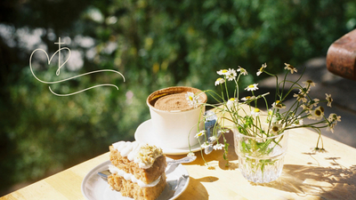 Ein Stück Kuchen und eine Tasse Kaffee auf einem Holztisch im Freien, begleitet von einer kleinen Vase mit Blumen