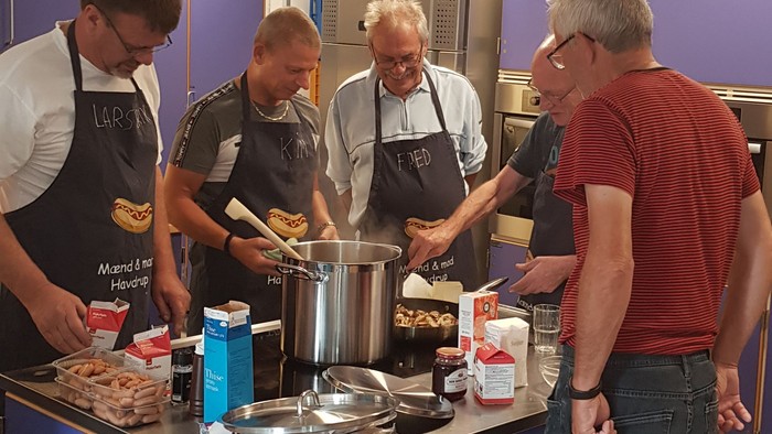 Fire mænd koker sammen i en professionel køkken.