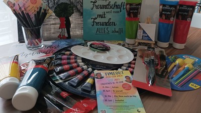 Buntstifte, Farben, Pinsel und Bücher auf dem Tisch