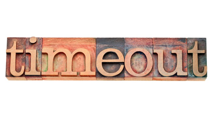 Holzklötze, die in einem vintagehaften, geschichteten typografischen Stil „Timeout“ buchstabieren.