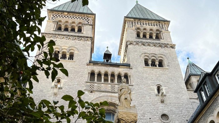 Zwei hohe Türme eines gotischen Gebäudes mit spitzen Dächern und zahlreichen Fenstern.