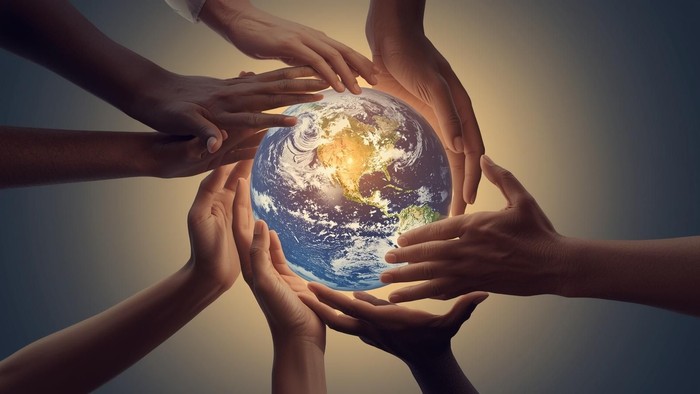 Hænder, der omkranser en globus, som symboliserer global enhed og miljøbeskyttelse.