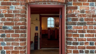 En rød murstensportal med lys over døren