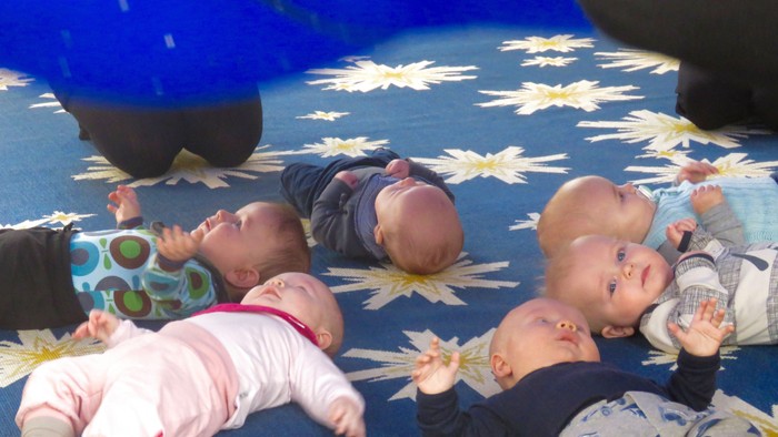 Fire spæd i farverne blå, hvid og blålig på blå gulvteppe med gule blomster.