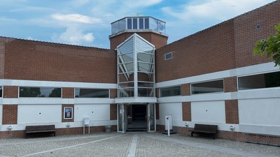 Et moderne bygning med en glasopstaltning og røde mursten.