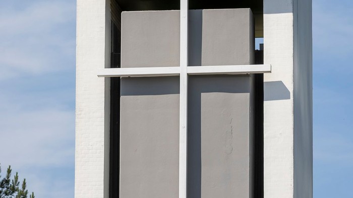 Højt, kvadratisk tårn med rødt tag og to vinduer.