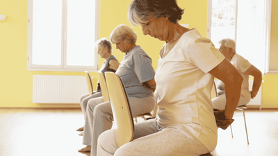 Eine Gruppe älterer Menschen sitzt in einem Raum und scheint sich zu unterhalten.