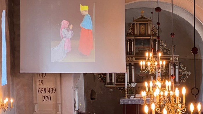 Kirkeinteriør med projektion, krystalkrone og alter