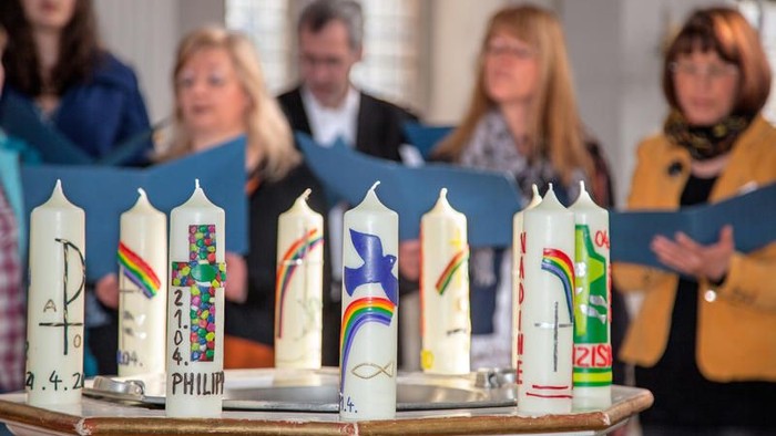 Bunte Kerzen mit Namen und Symbolen werden während einer Zusammenkunft oder Zeremonie mit aufmerksamen Teilnehmern präsentiert.