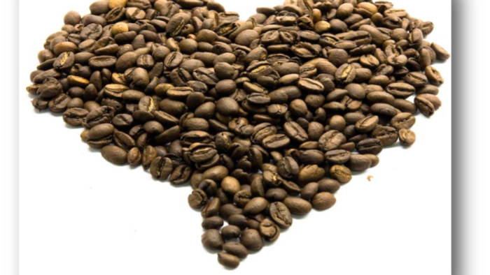 Et hjerte lavet af kaffebønner på et hvidt baggrund