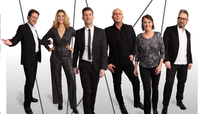 Seks personer i formel påklædning, der poserer sammen, med ordet