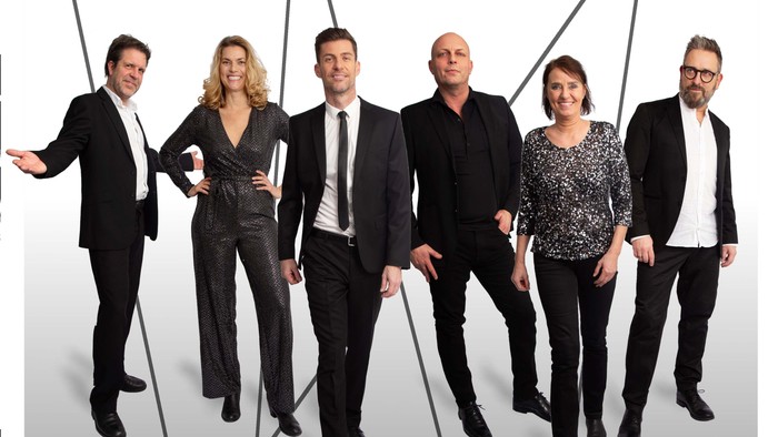 Seks personer i formel påklædning, der poserer sammen, med ordet 