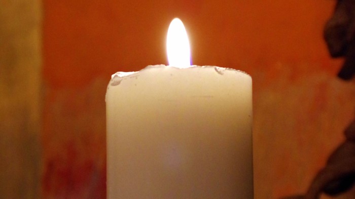 En lysende lysekone foran rød væg.