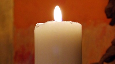 En lysende lysekone foran rød væg.