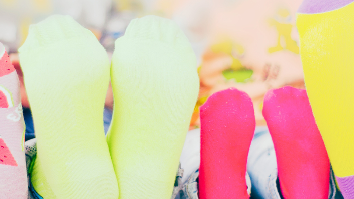 En række isbærer i farverne rosa, grøn og gul med frugtformede topper.