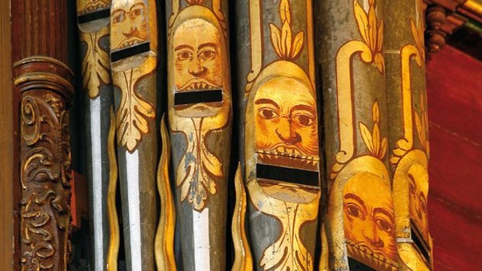 Ornate Holzpfeifenorgel mit kunstvollen Schnitzereien und goldenen Akzenten