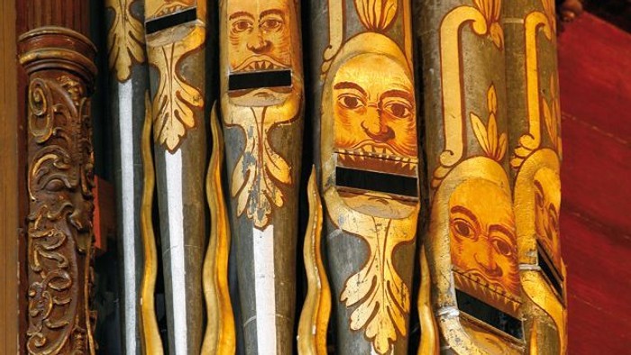 Ornate Holzpfeifenorgel mit kunstvollen Schnitzereien und goldenen Akzenten