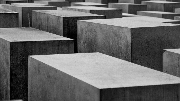 Grauschwarze Kuben in einem gitterartigen Muster angeordnet