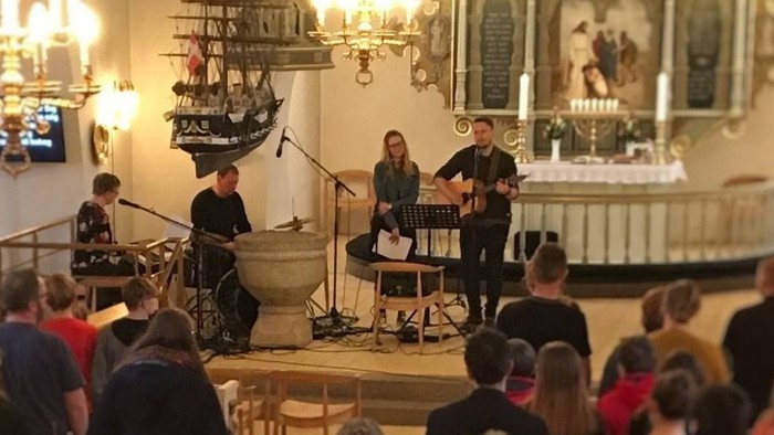 En koncert i kirke med publikum og musikere på scene