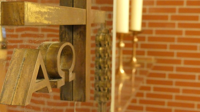 Goldene Buchstaben an Ziegelwand