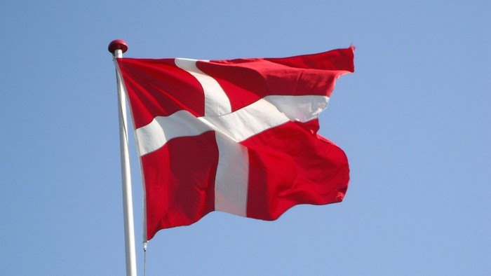 Danish flag waving in clear blue sky
