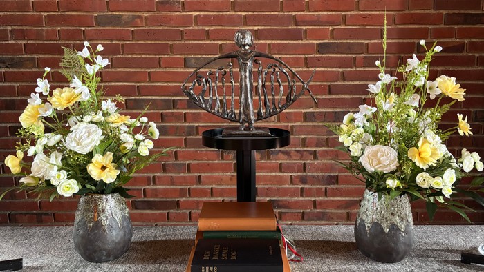 To dyrkevaser med blomster til hver side af en oldemåler