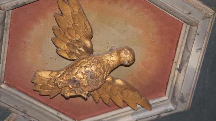 Goldener Vogel auf rotem Hintergrund in einem Rahmen