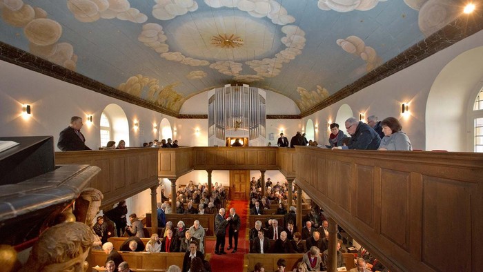 Kircheninneres mit Gemeinde und Orgel