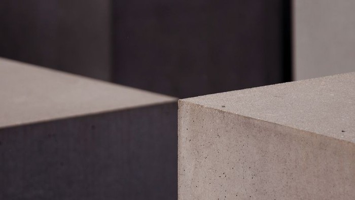 Zwei graue Betonblöcke vor dunklem Hintergrund