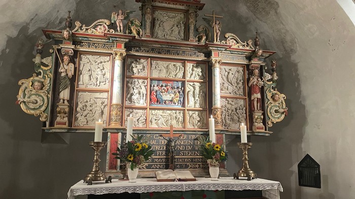 Altar in Kirchenraum mit aufwendiger Barockdekoration und Kerzen
