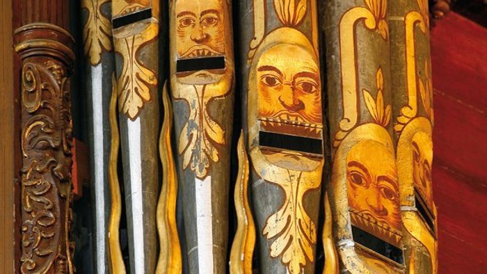 Ornate Holzpfeifenorgel mit kunstvollen Schnitzereien und goldenen Akzenten