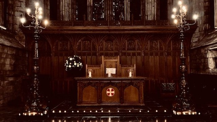 Church altar with candles and chandeliers.