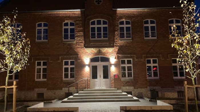 Eingangsbereich eines großen Backsteingebäudes bei Nacht