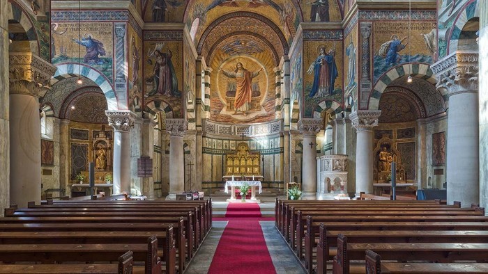 Innenraum einer prächtigen Kirche mit Säulen, Altarraum und religiösen Kunstwerken