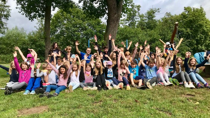 Gruppe von Menschen, die im Freien posieren mit Bäumen im Hintergrund