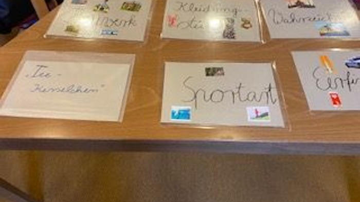 Handschriftliche Notizen und Karten mit verschiedenen Botschaften und Aufklebern auf einem Holzregal.