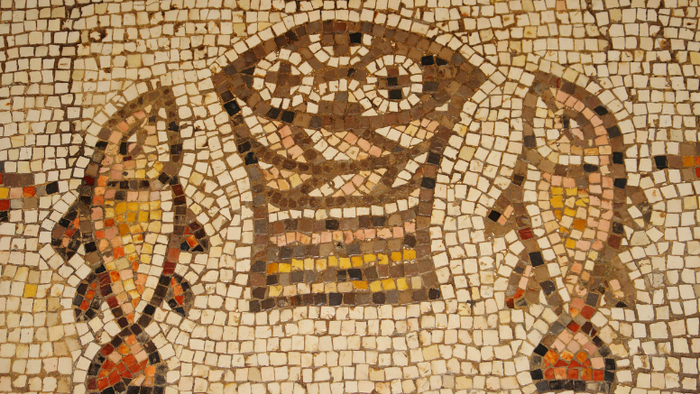 Historisk vikingetids-mosaikkunst og et malerisk skandinavisk kirke med et højt tårn og røde tage.