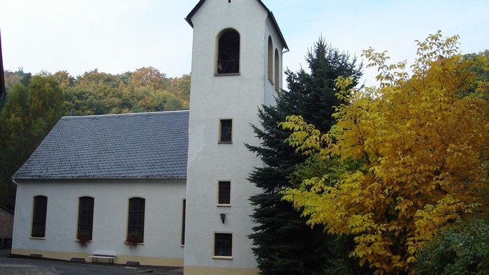 Weißes Gebäude mit Turm neben Bäumen