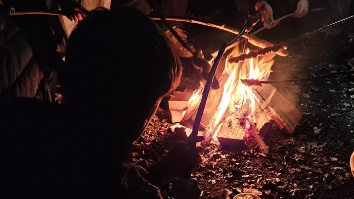 Kinder / Jugendliche um ein Lagerfeuer mit Stockbrot
